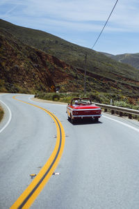 Vehicles on road against mountain