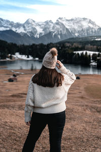 Rear view of woman standing on mountain during winter