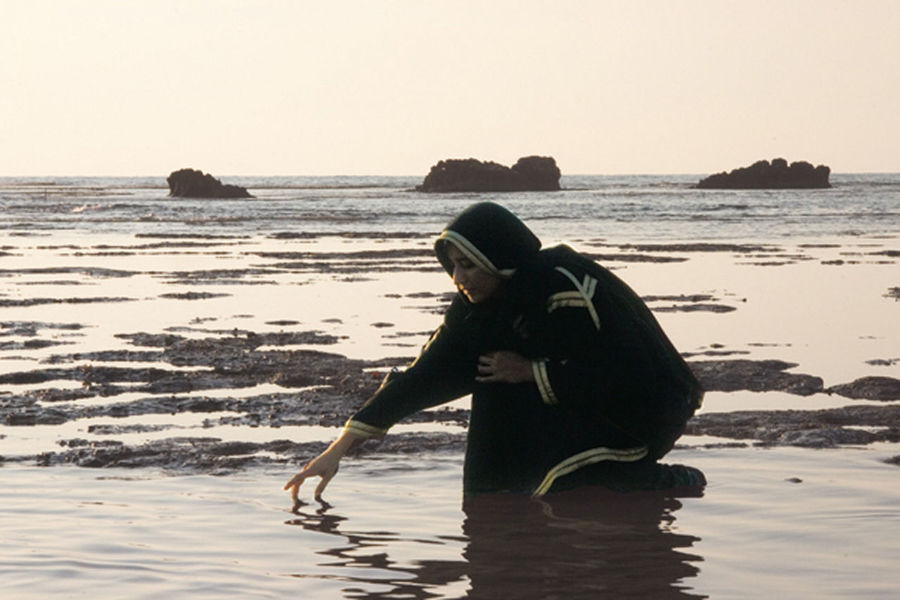 SIDE VIEW OF MAN STANDING AT BEACH