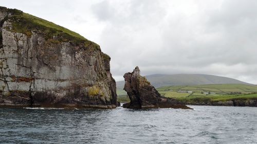 Rock formations by sea against sky