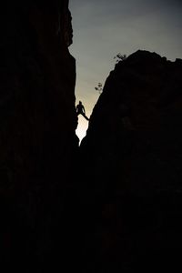 Low angle view of silhouette cliff against sky