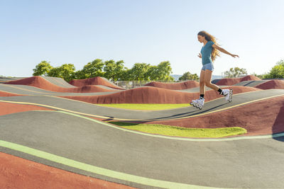 Young woman practicing roller skating on pump track