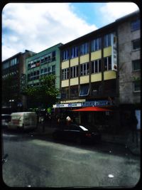 Buildings in city against cloudy sky