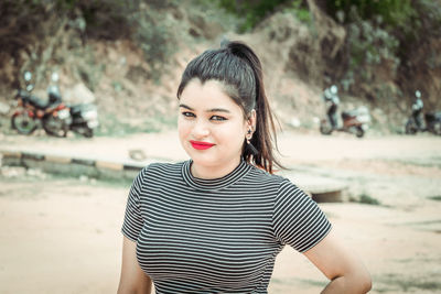 Portrait of smiling young woman standing on land