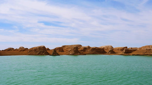 Rock formations by sea against sky