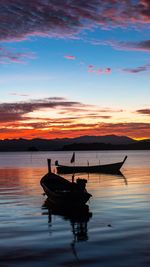 Silhouette boat in sea against sky during sunset