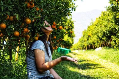 Smiling woman under the orange tree