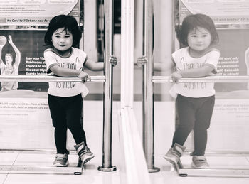 Full length of girl standing against wall