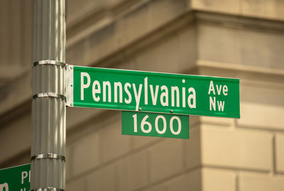 Low angle view of road sign against building