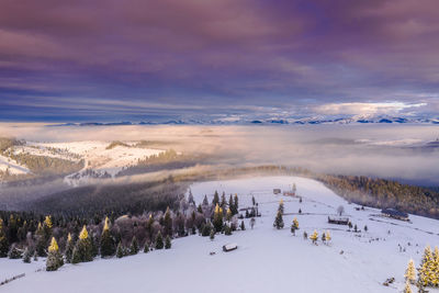 Scenic view of snow covered landscape against sky during sunset