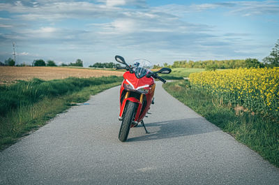 Man riding bicycle on road amidst field