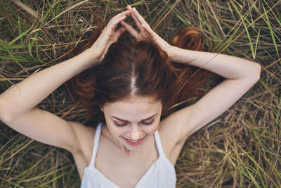 Portrait of a young woman lying down on field