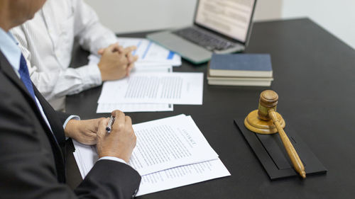 Midsection of businessman working at desk in office