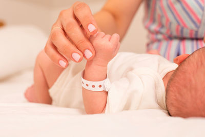 Cropped hand of mother taking care of baby