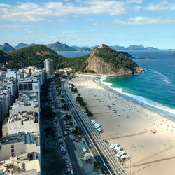 High angle view of city by sea against sky