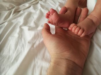 Cropped hand of parent touching baby feet