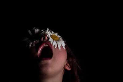 Woman with flowers of eyes against black background