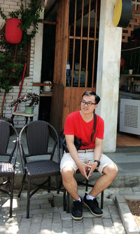 Full length of young man sitting on chair