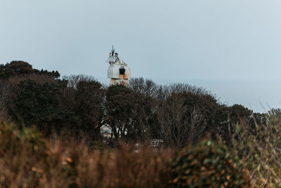 Lighthouse by sea against sky