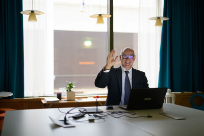 Man using phone while sitting on table