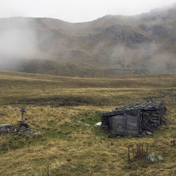 Abandoned house on field against sky