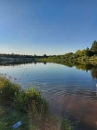 Scenic view of lake against clear blue sky