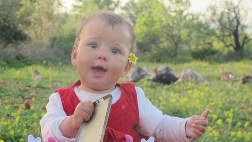 Close-up of cute baby girl with phone cover at park