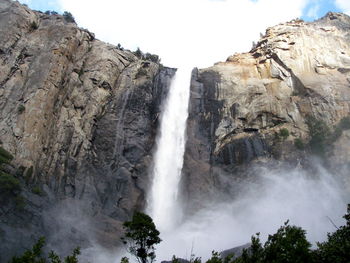 Scenic view of waterfall against sky