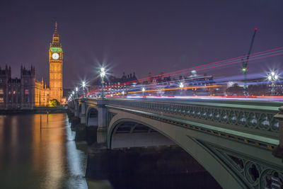 Westminster bridge over thames river against sky at night