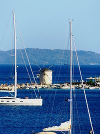 Sailboats sailing on sea against clear blue sky