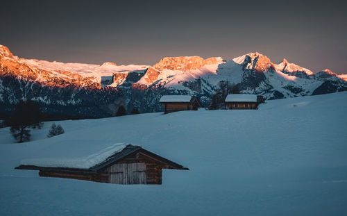 Houses on snow covered landscape against sky