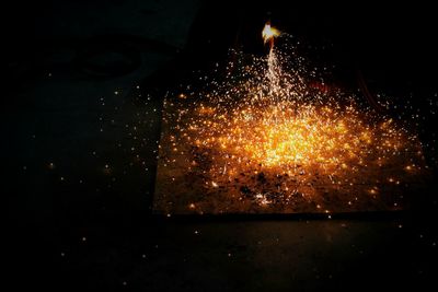 Close-up of illuminated lighting equipment against black background