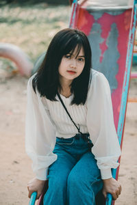 Portrait of young woman sitting outdoors