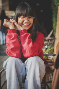 Portrait of smiling girl sitting at balcony