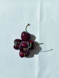 Close-up of cherries on table against white background