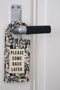 Close-up of do not disturb board hanging on door handle