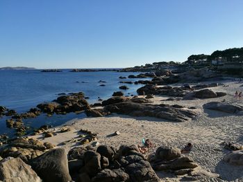 Scenic view of rocky shore against clear sky