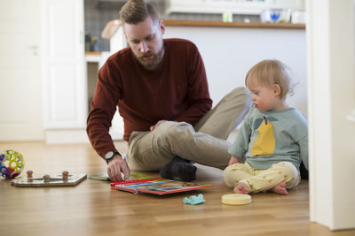 Siblings playing with toy blocks at home