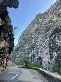 Road amidst rocky mountains against sky