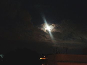 Illuminated lighting equipment against sky at night