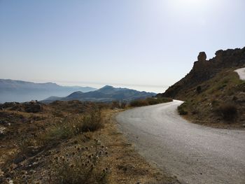 Road amidst mountains against clear sky