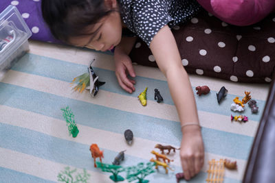 High angle view of girl playing with toys on table