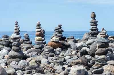 Stack of stones on rocky shore at sea