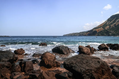 Rocks on beach against sky