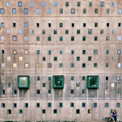 Woman sitting by patterned wall