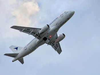 Low angle view of airplane flying against sky