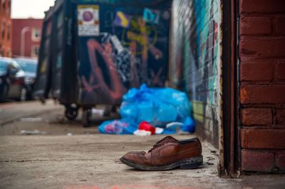 Shoe on sidewalk by wall