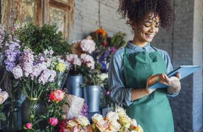 Portrait of young woman picking fruits at market