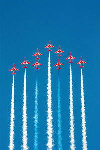 Low angle view of airplane flying against clear blue sky