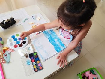 High angle view of baby girl playing on floor at home